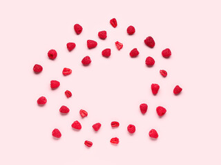 Frame made of fresh raspberries on pink background