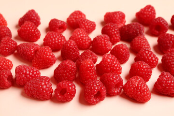 Many fresh raspberries on pink background