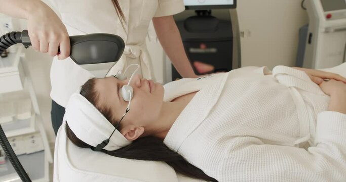 Beauty woman with protective glasses, Woman getting LPG hardware massage at the beauty clinic. Close up of a young girl getting laser face treatment in a medical center, skin rejuvenation concept.