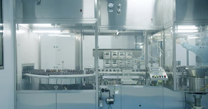 Sterile Pharmaceutical Manufacturing Laboratory where Scientists in Protective Coveralls. Factory Cleanroom. Pharmaceutical, Biotechnological and Semiconductor Creating Manufacturing Process.
