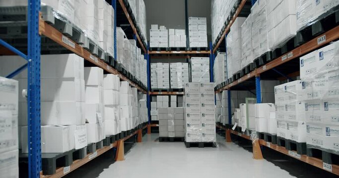 Industrial interior storage room. Products at the warehouse. Retail Warehouse full of Shelves with Goods in Cardboard Boxes. Huge, large modern warehouse.