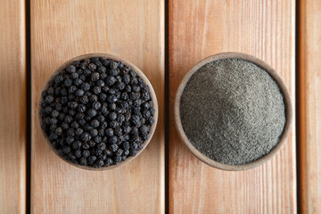Ground black pepper with peppercorns on a wooden table,top view
