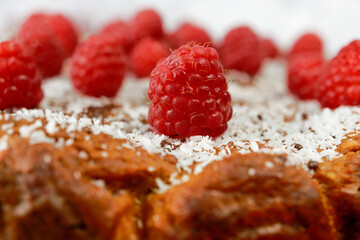 close-up homemade sweet potato pie with raspberries and shredded coconut on a red plate