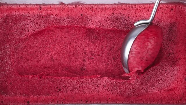 Strawberry ice cream in a porcelain bowl on a marble cutting board. Dark background. Dessert advertising concept