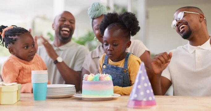 Birthday, children party and applause with a family in celebration of a girl child in their home. African parents, grandparents and kids clapping while blowing candles on a cake at a milestone event