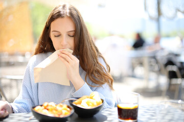 Restaurant customer cleaning mouth with napkin in terrace