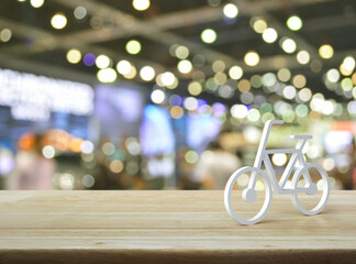 Bicycle 3d icon on wooden table over blur light and shadow of shopping mall, Business bicycle service concept