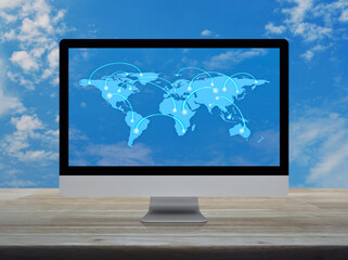 Connection line with global world map on computer monitor screen on wooden table over blue sky, Technology communication online concept, Elements of this image furnished by NASA