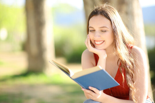 Happy reader reading a paper book in nature