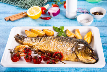 Fresh tasty food fish crucian carp served on old blue wooden table with cooking ingredients