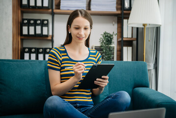 Obraz premium Caucasian businesswoman working in the office with working notepad, tablet and laptop documents on sofa in home office
