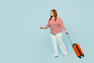 Traveler chubby overweight woman wears casual clothes hold bag walk go isolated on plain blue background studio Tourist travel abroad in free spare time rest getaway Air flight trip journey concept.