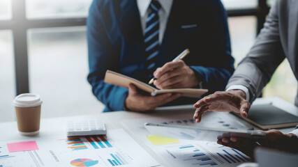 Group of business people working together on new project with planning analytical report at meeting. Businesspeople meeting together pointing to graph assess business profits.