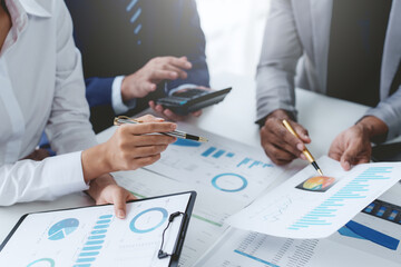 Group of business people working together on new project with planning analytical report at meeting. Businesspeople meeting together pointing to graph assess business profits.