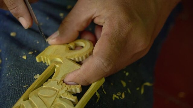 The process of carving dolls made of wood, all done handmade using a small knife. Javanese traditional wooden puppet making by professional craftsmen. Shot up close and slow motion