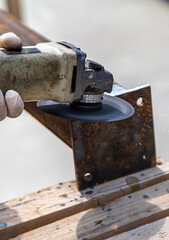 A man processes a metal pole. Selective focus.