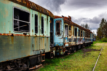 Fototapeta na wymiar Old rusty electric multiple units abandoned on unused railway tracks