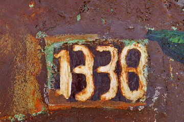 Numéro 1338. Numéro de rue sur porte rouillée.