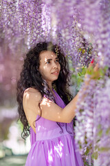 Woman wisteria lilac dress. Thoughtful happy mature woman in pur