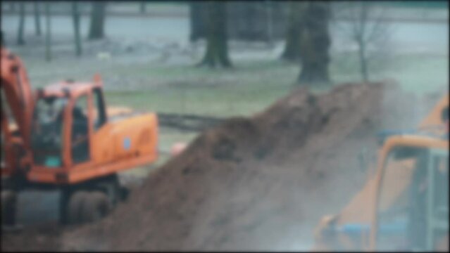 The excavator is digging a hole. Construction work is underway to lay and replace the heating mains, industry. Blurred, copy space for text