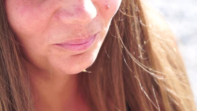 A woman eats a dried persimmon. Young happy woman vomits and eats dried persimmon after morning fitness yoga by the sea. Healthy vegan food. Slow motion