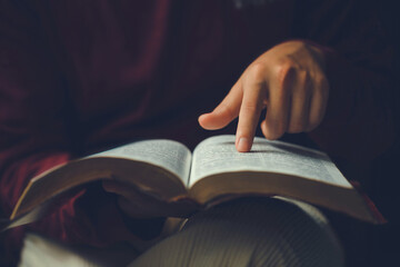 Christian man's hands while reading the Bible outside.Sunday readings, Bible education. spirituality and religion concept. Reading a book.education learning