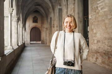 Young tourist photographer visiting ancient city - Smiling woman with camera enjoying vacations in...