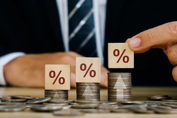 Interest rate,Financial and dividend concept.Businessman holding wooden block with percentage...
