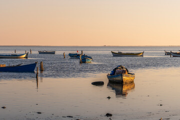 Obraz premium boats reflections and sky in still water at sunset