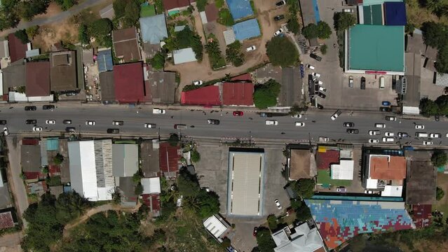 island village of Mae Nam with road traffic and houses - birds view angle - Koh Samu island in Thailand - take from drone - pull up scene