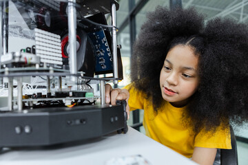 Girl with afro hairstyle education electronic on table at class room. learning innovation electronic for future AI. electric system skill training. STEM education concept.