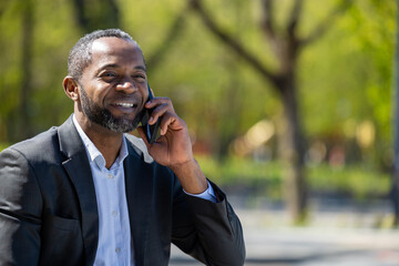 African american businessman talking on the phone and looking excited