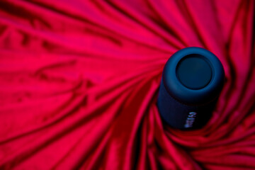 The concept of modern technology. Close-up of a matte black smart portable wireless speaker on a...