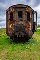 Fototapeta na wymiar Old rusty passenger car abandoned on railway tracks