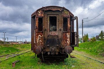 Fototapeta na wymiar Old rusty passenger car abandoned on railway tracks