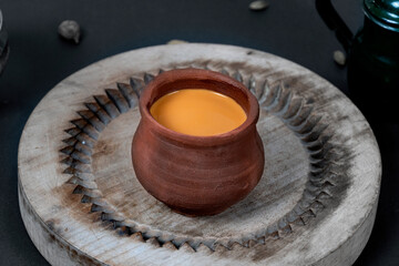 Fresh milk tea or indian karak chai or masala tea in clay cup on black background