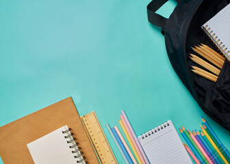 Backpack with stationery on blue background