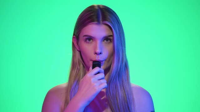 Kobieta mali elektronicznego papierosa i wypuszcza dym