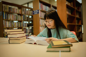 Little girl posing in public library room selecting for reading. girl chooses books on shelves learning from books and notebook is school education benefits of everyday reading concept.