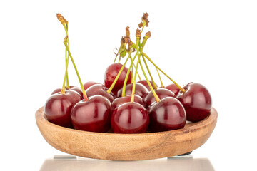 Several ripe cherries with a wooden plate, macro, isolated on a white background.