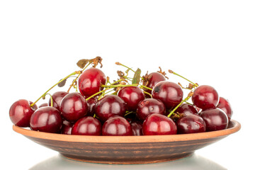 Several ripe cherries with a clay plate, macro, isolated on a white background.