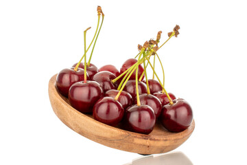 Several ripe cherries with a wooden plate, macro, isolated on a white background.