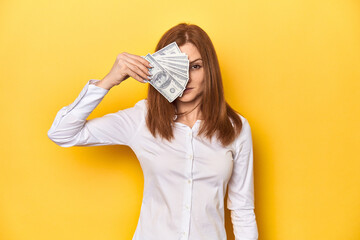 Redhead holding dollar bills, finance and wealth concept.