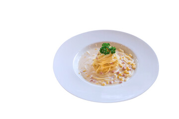 Spaghetti with ham and corn cream sauce put on a white plate while isolated on white background.