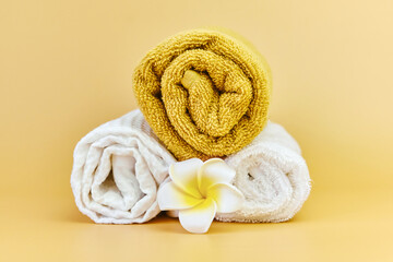 Obraz na płótnie Canvas Stack of roll folded towels on a beige background,