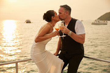 couple drinking and kissing in luxury yacht