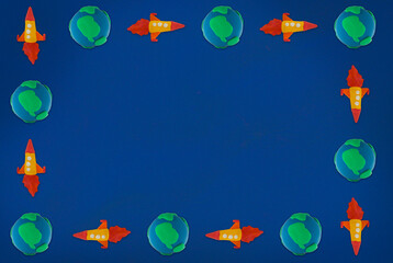 Fototapeta na wymiar plasticine yellow rocket blue green earth on blue background