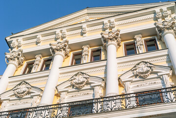 Obraz premium Decoration of stucco on the facade of an old building of the 19th century. The facade of a mansion built in the 19th century. Ancient architecture with stucco on the facade.
