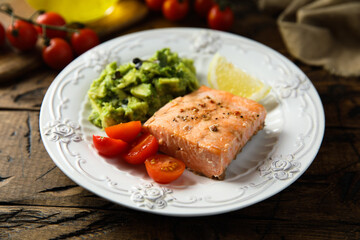 Healthy baked salmon fillet with mashed avocado