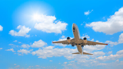 Fototapeta na wymiar White passenger airplane flying in the sky amazing clouds in the background - Travel by air transport